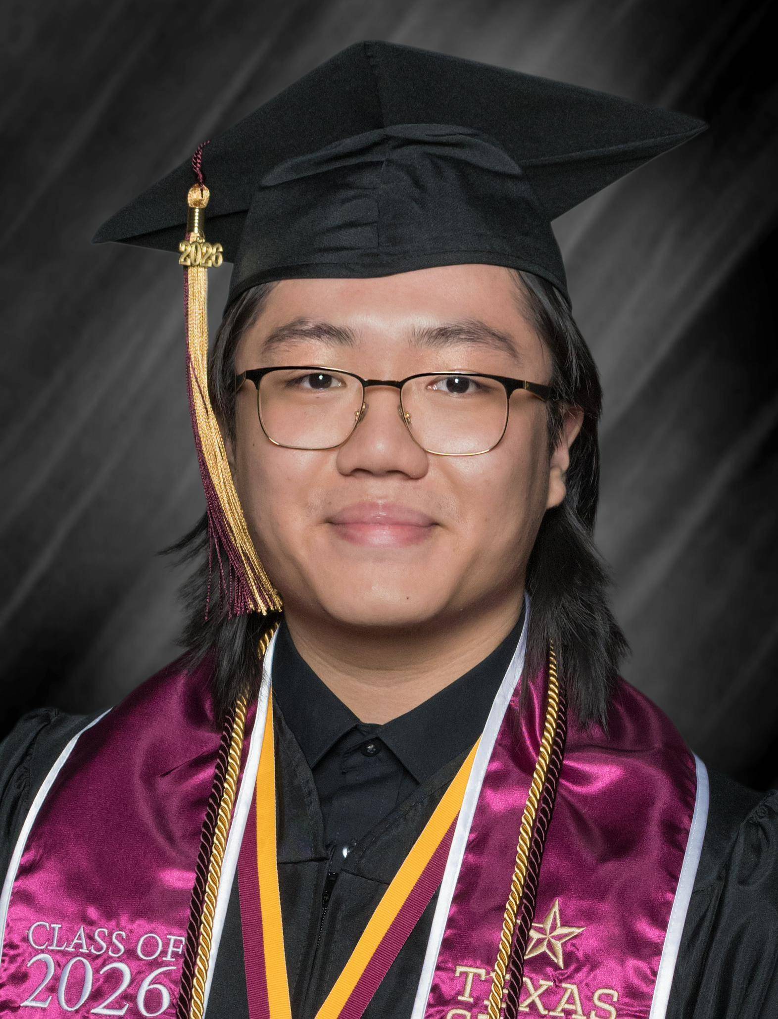 man in graduation regalia poses for professional photo